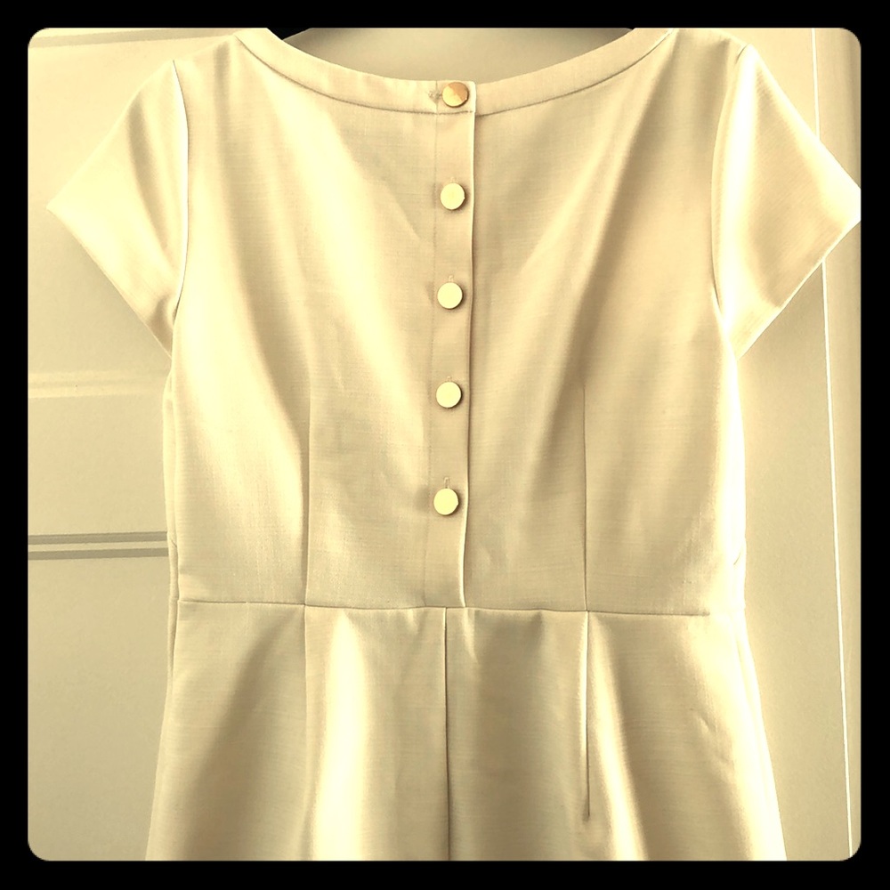 White dress with gold buttons.